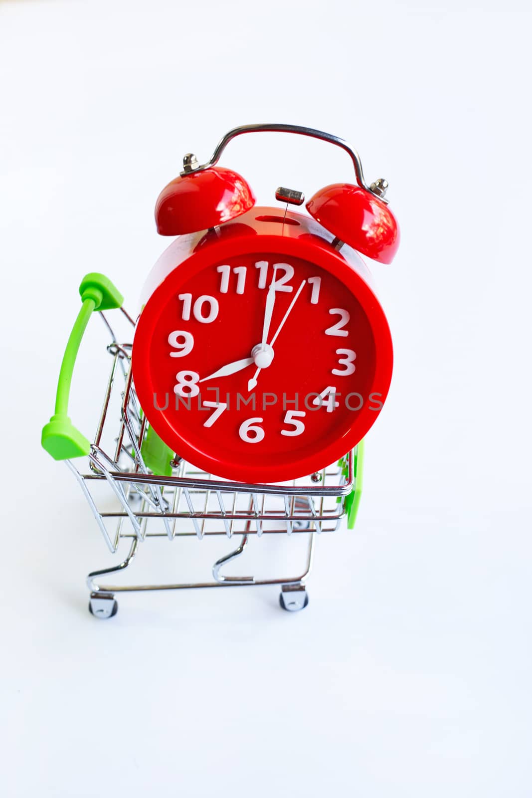 Alarm clock on shopping cart on white