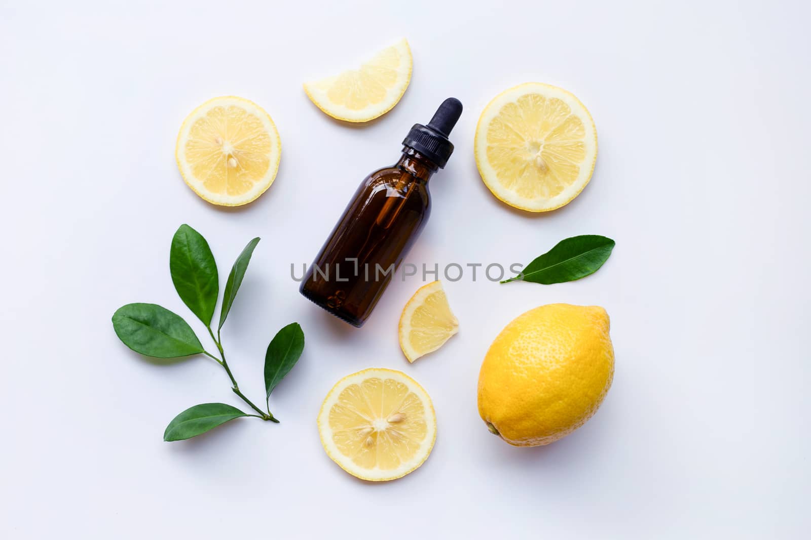 Fresh lemon with lemon essential oil on a white background.