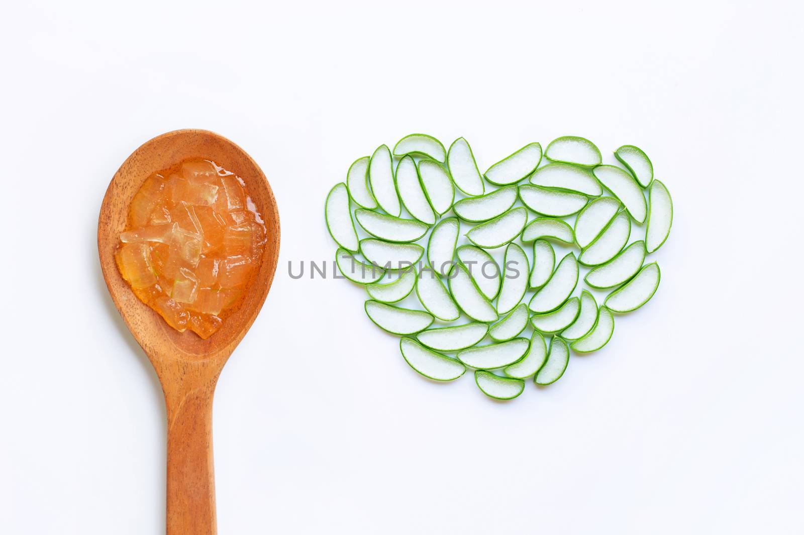 Aloe vera gel on wooden spoon with aloe vera slices on white background, heart shaped