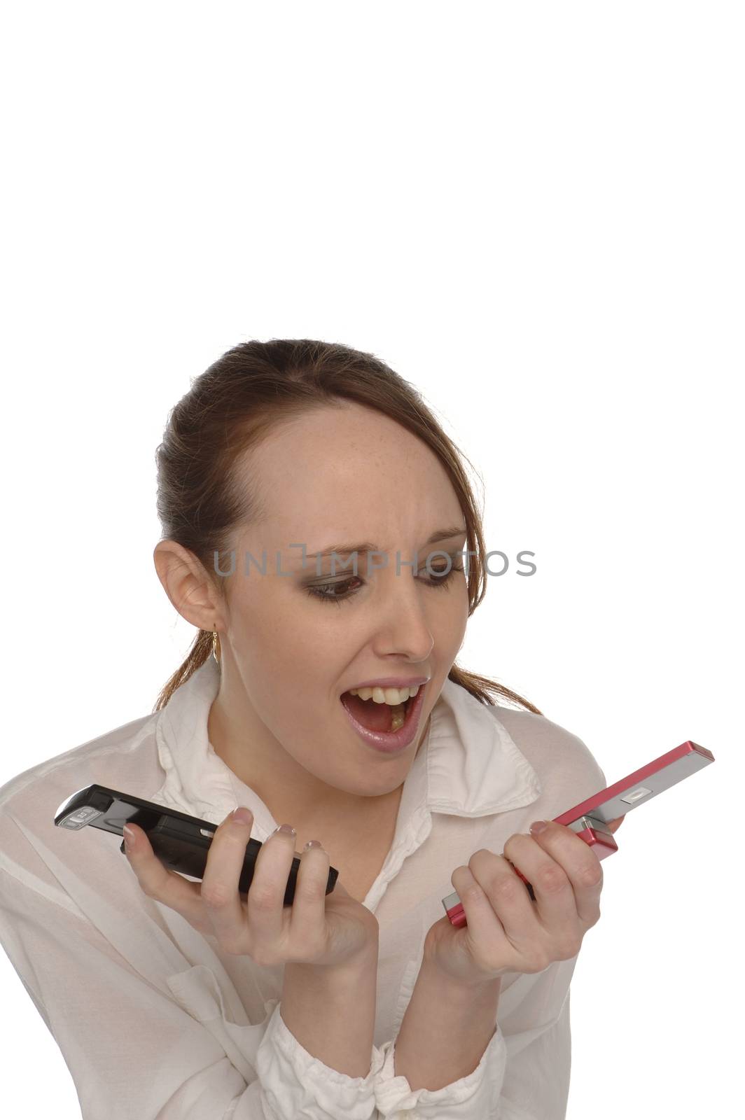Young woman confused by two mobile telephones