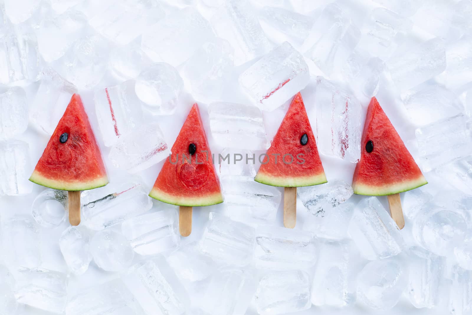 Sweet watermelon slice popsicles on ice background