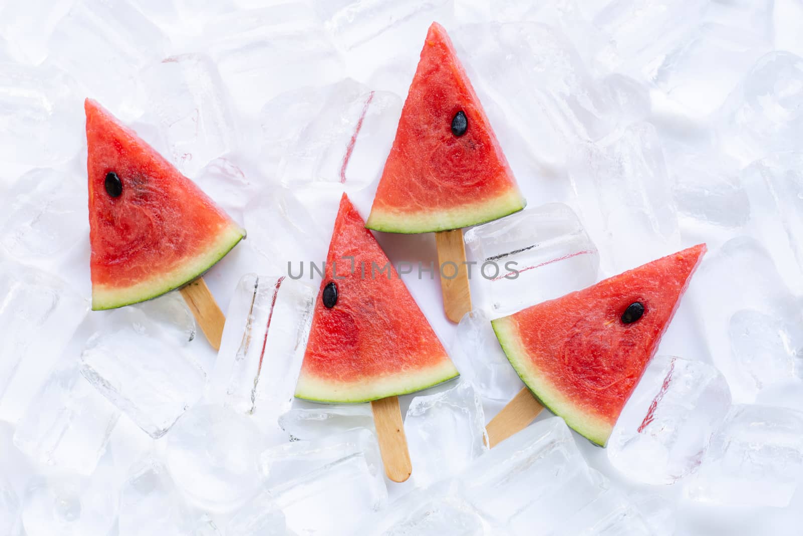 Sweet watermelon slice popsicles on ice background