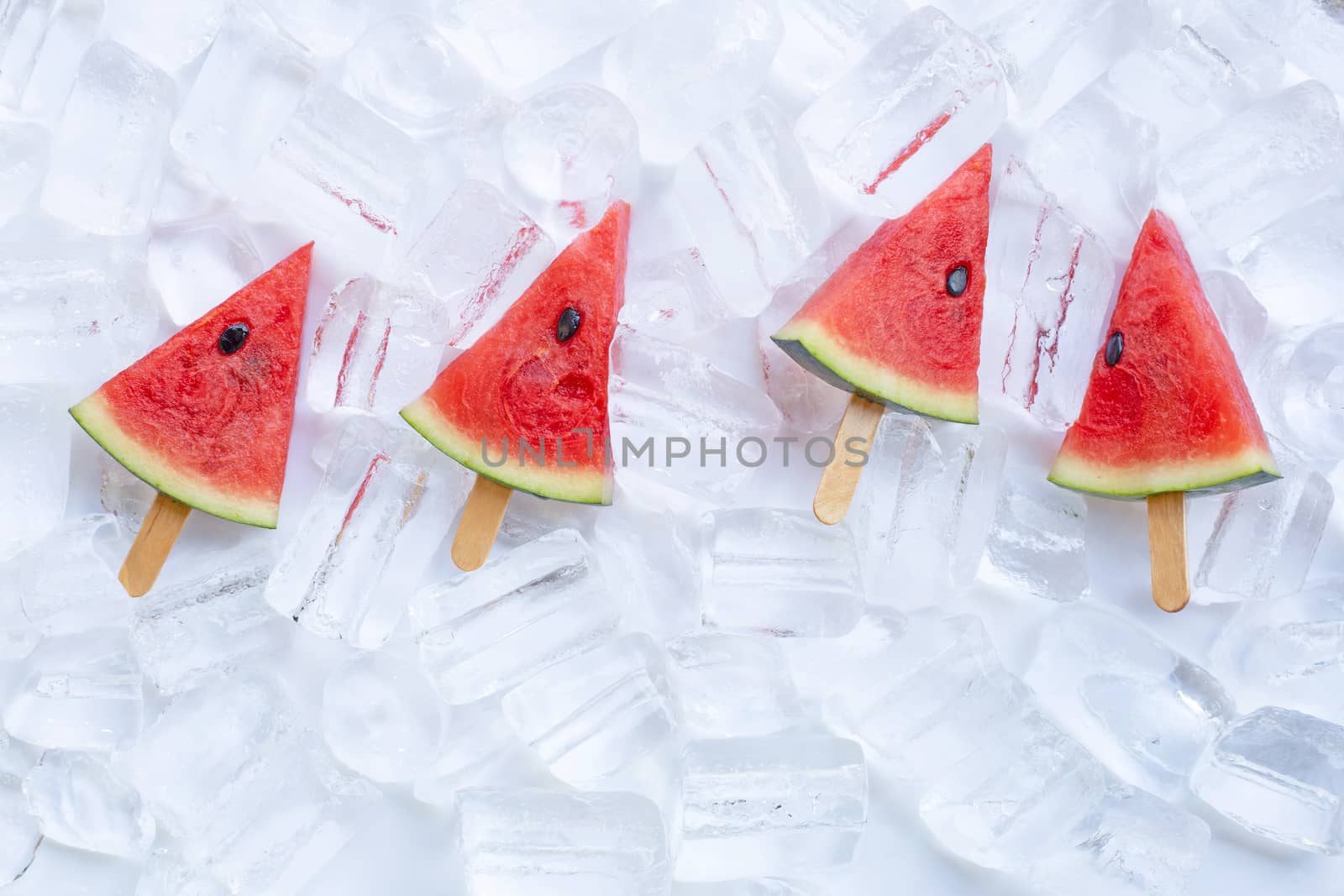 Sweet watermelon slice popsicles on ice background