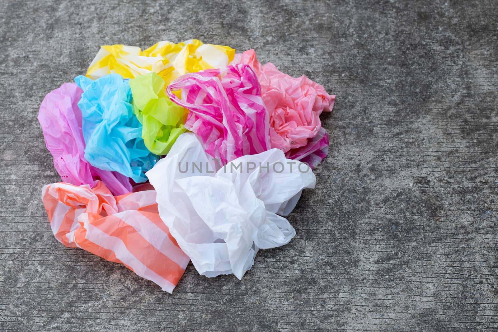 Colorful plastic bags on cement floor background.