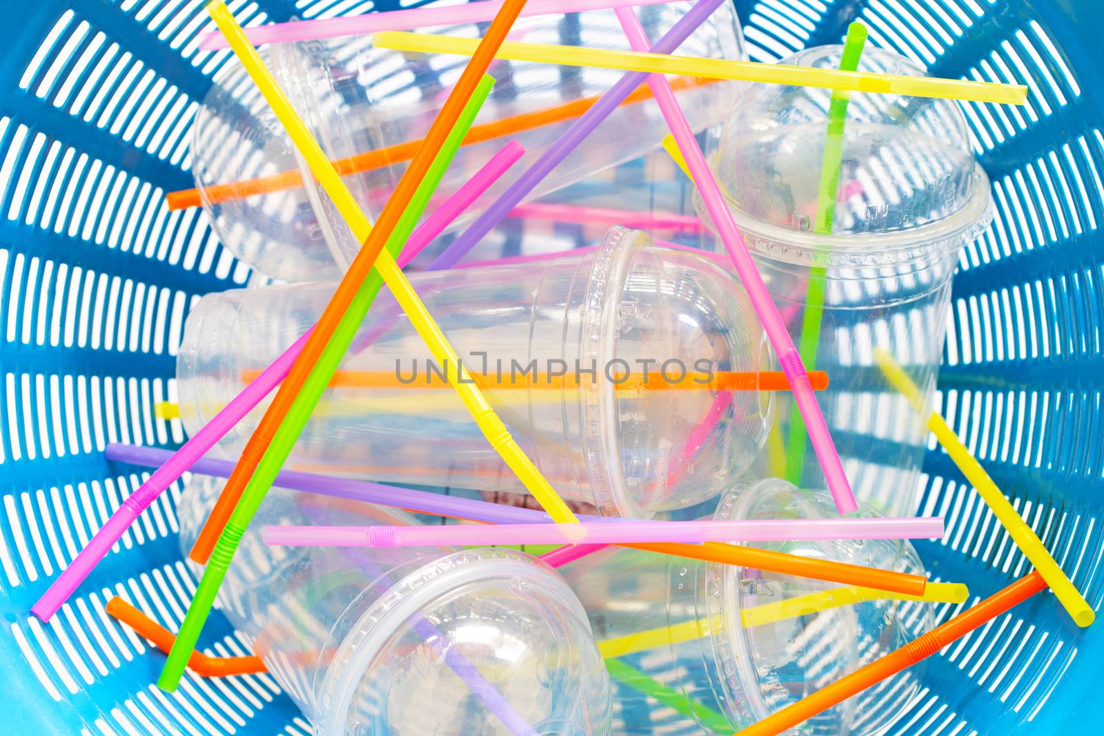 Plastic cups with straws in waste basket. top view