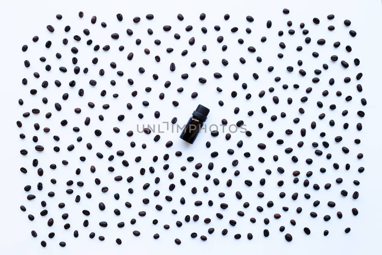 Glass bottle with essential oil of coffee and Coffee grains on white background