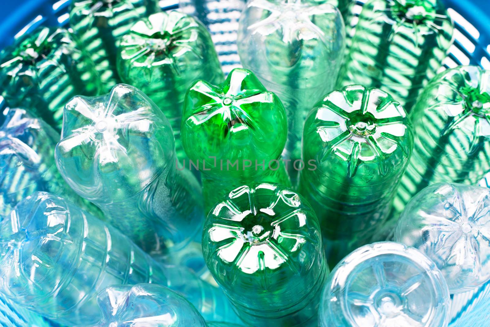 Plastic bottles in blue waste basket.