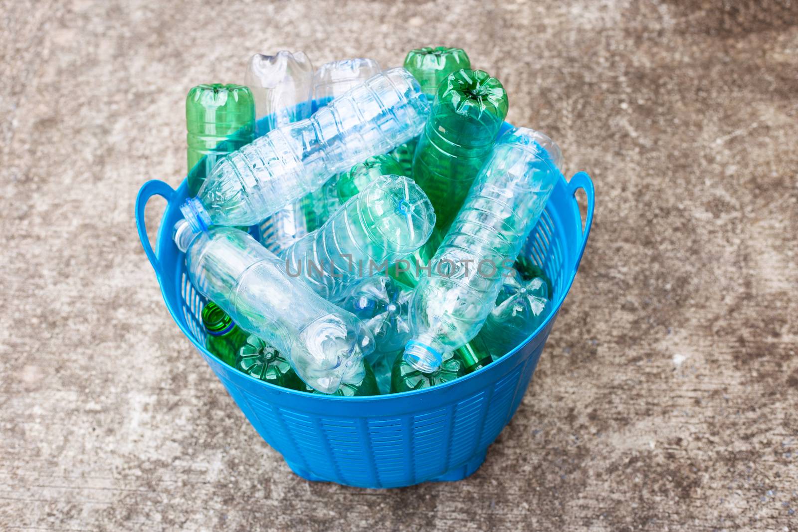 Plastic bottles in blue waste basket.