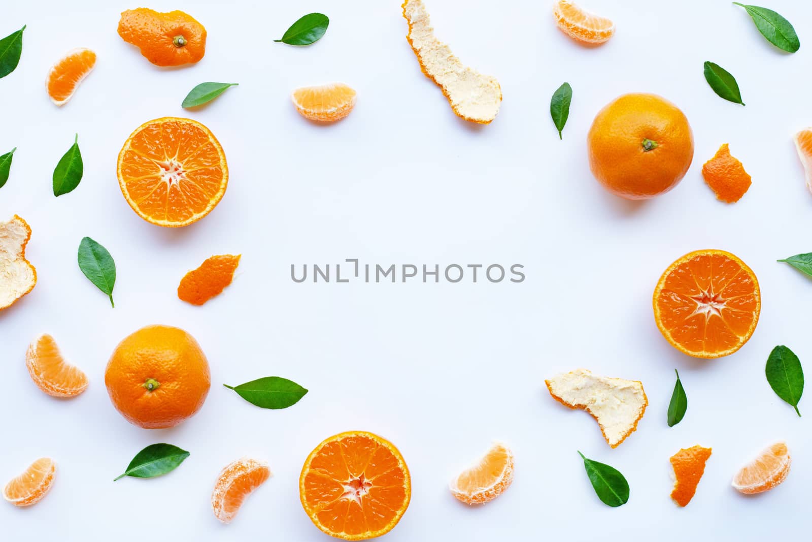 Frame of fresh orange citrus fruit with green leaves on white background.