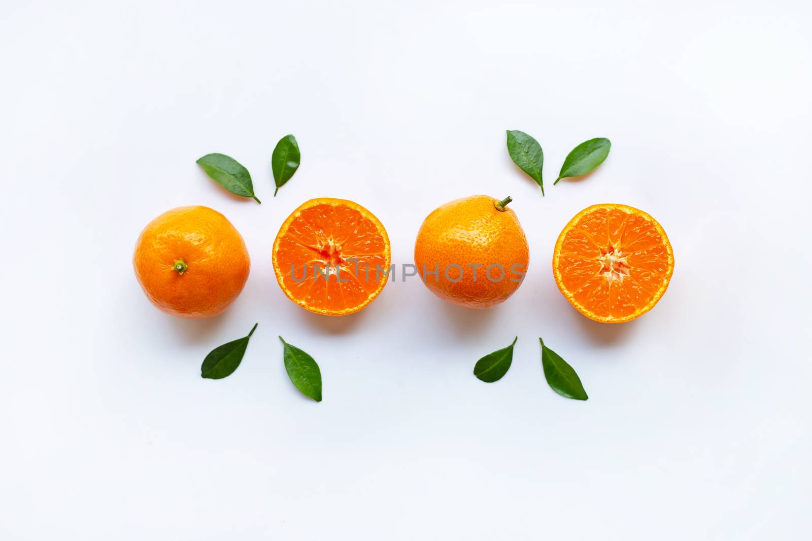 Orange fruits and green leaves on a white background. Top view