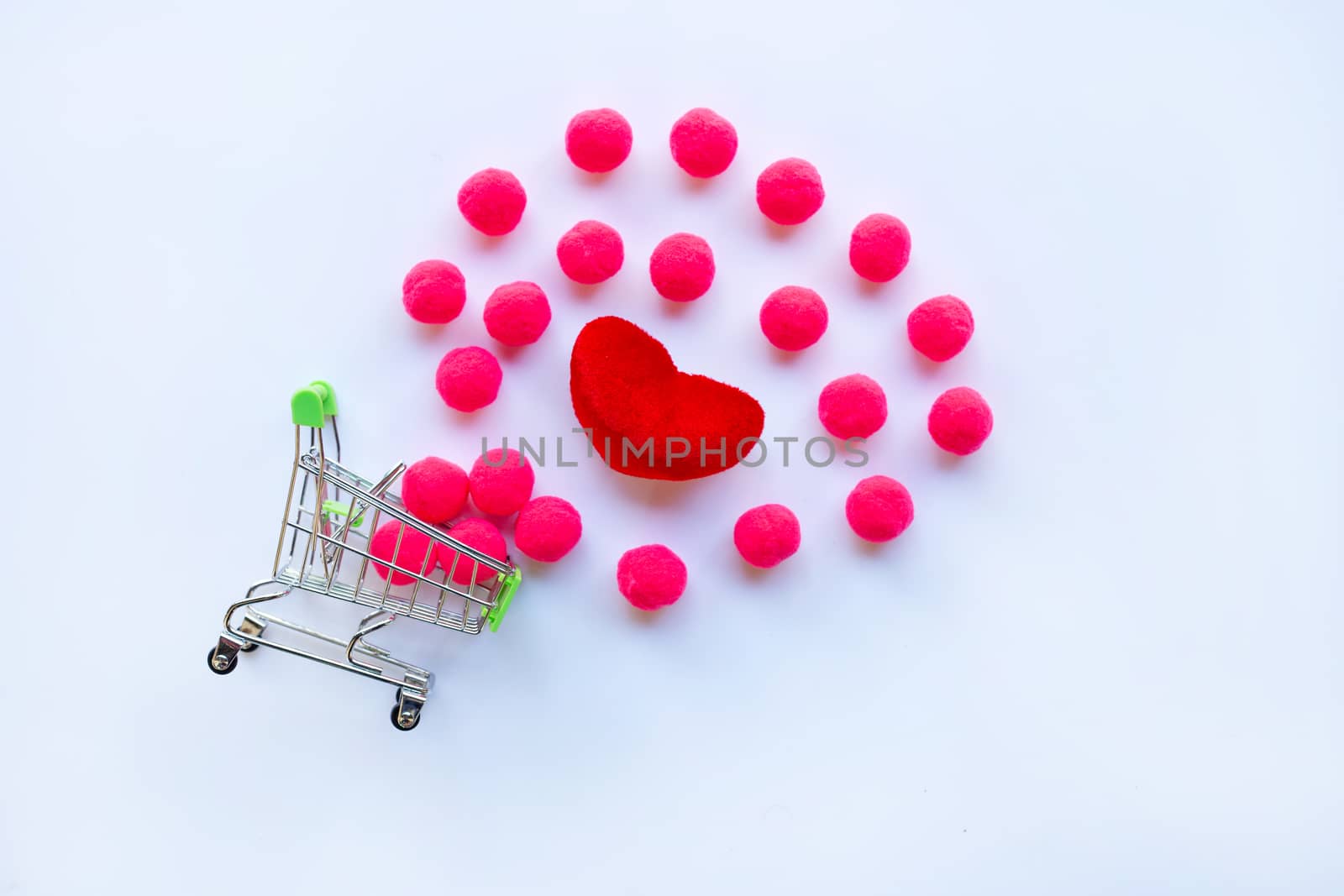Red heart and little pink balls with shopping cart on white background. Copy space, Concept background for Valentines Day 