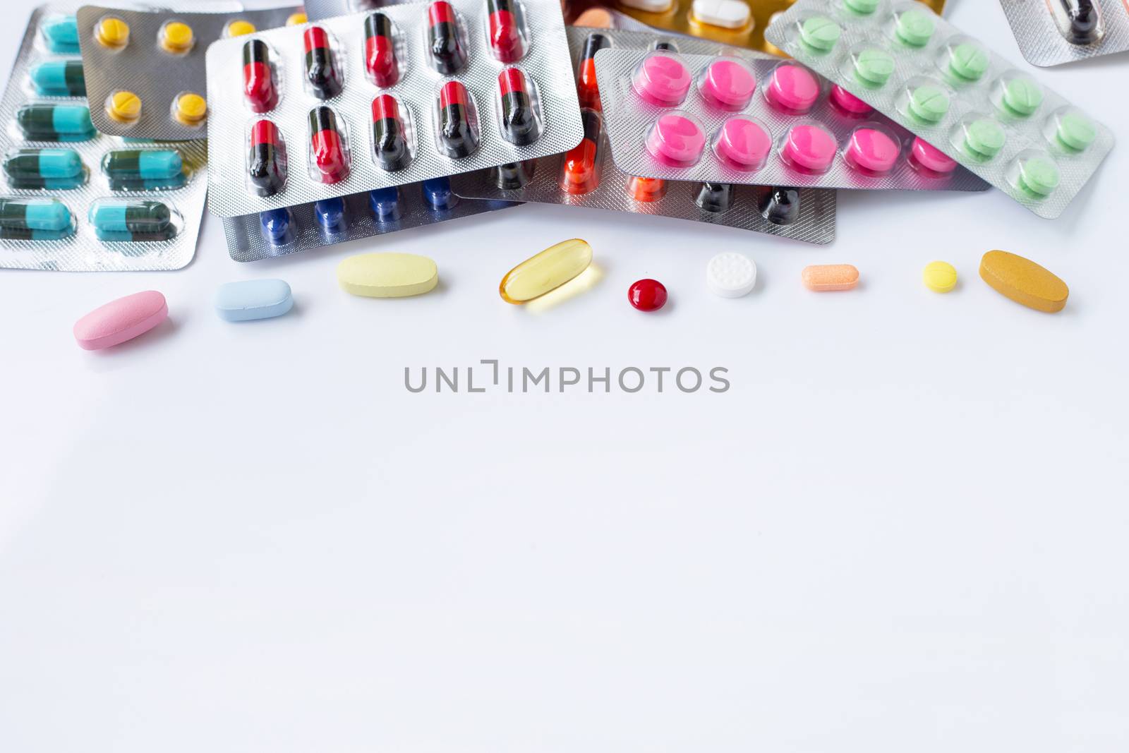 Various capsule medicines, pills and tablets in blister pack on white background.