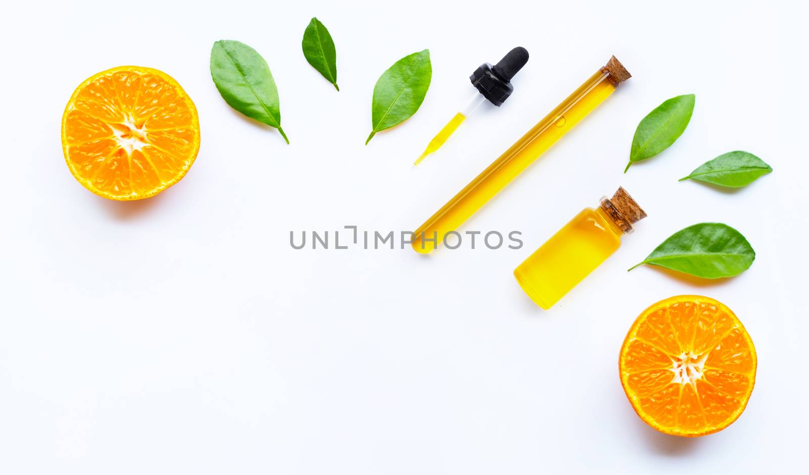 Essential oil with oranges on white background.