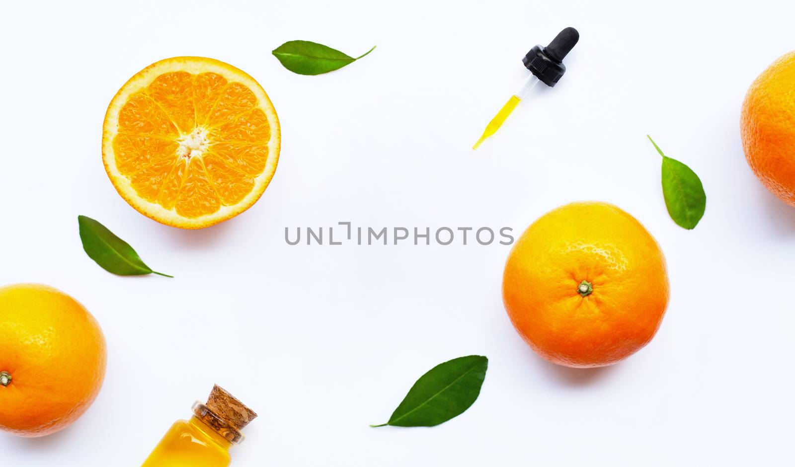 Essential oil with oranges on white background.