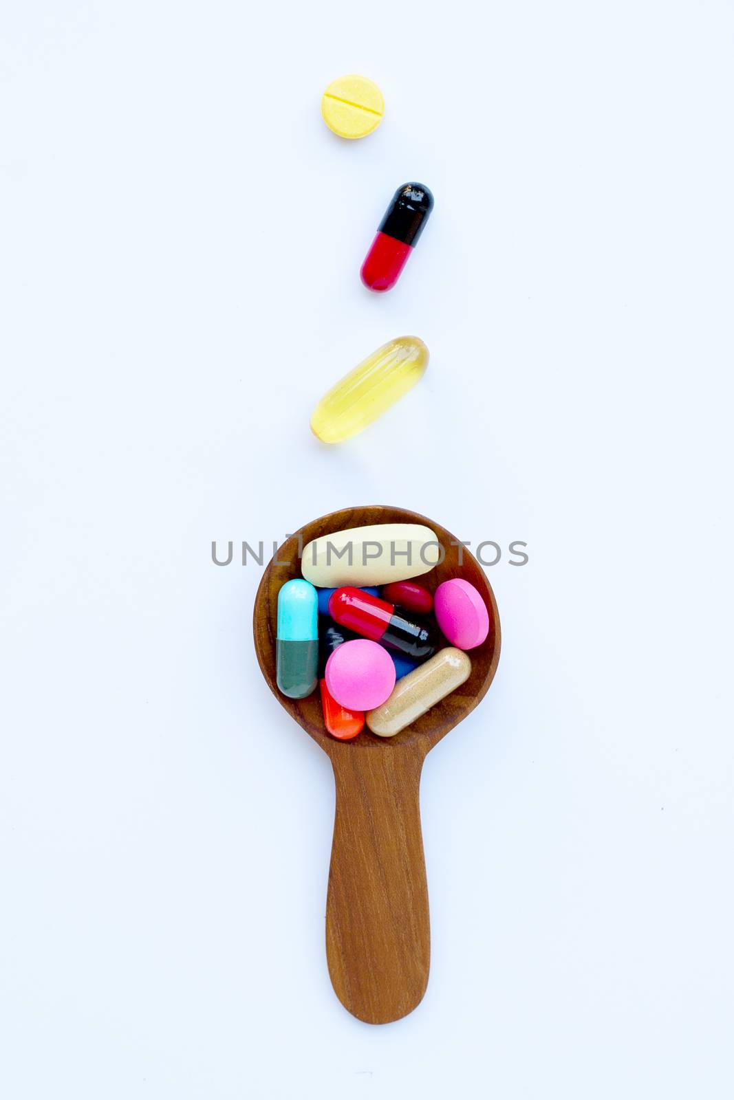 Colorful tablets with capsules and pills on white background.