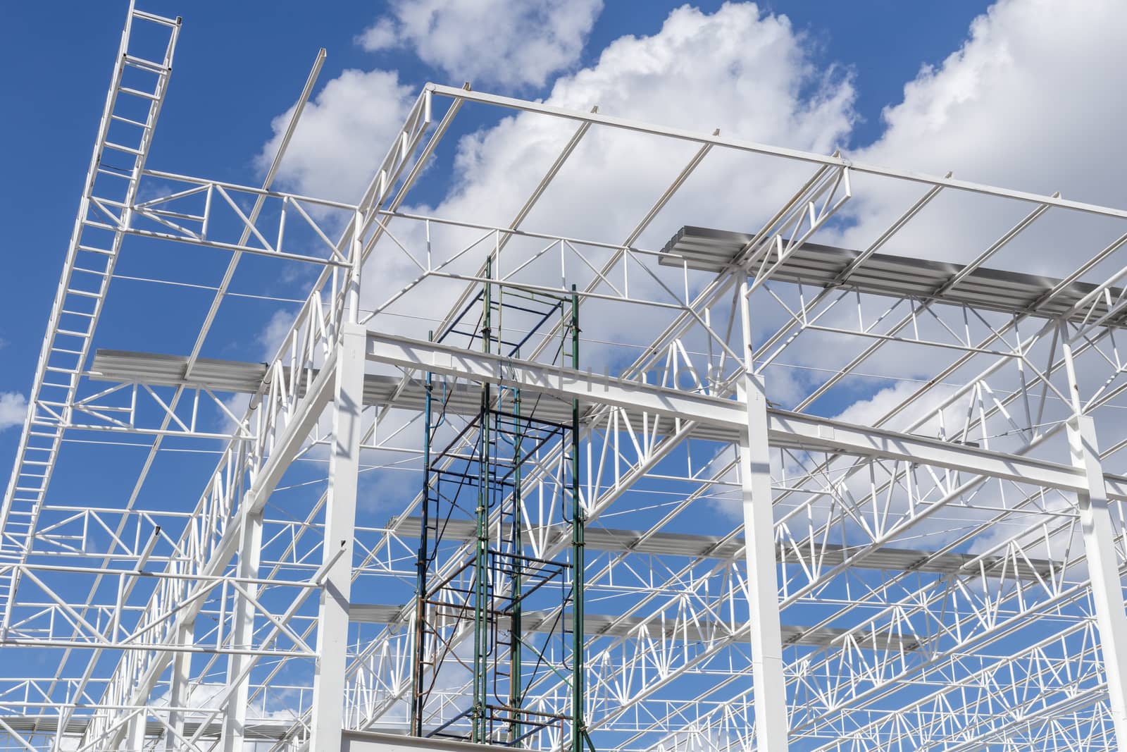 Construction of steel frame of big building with blue sky background.