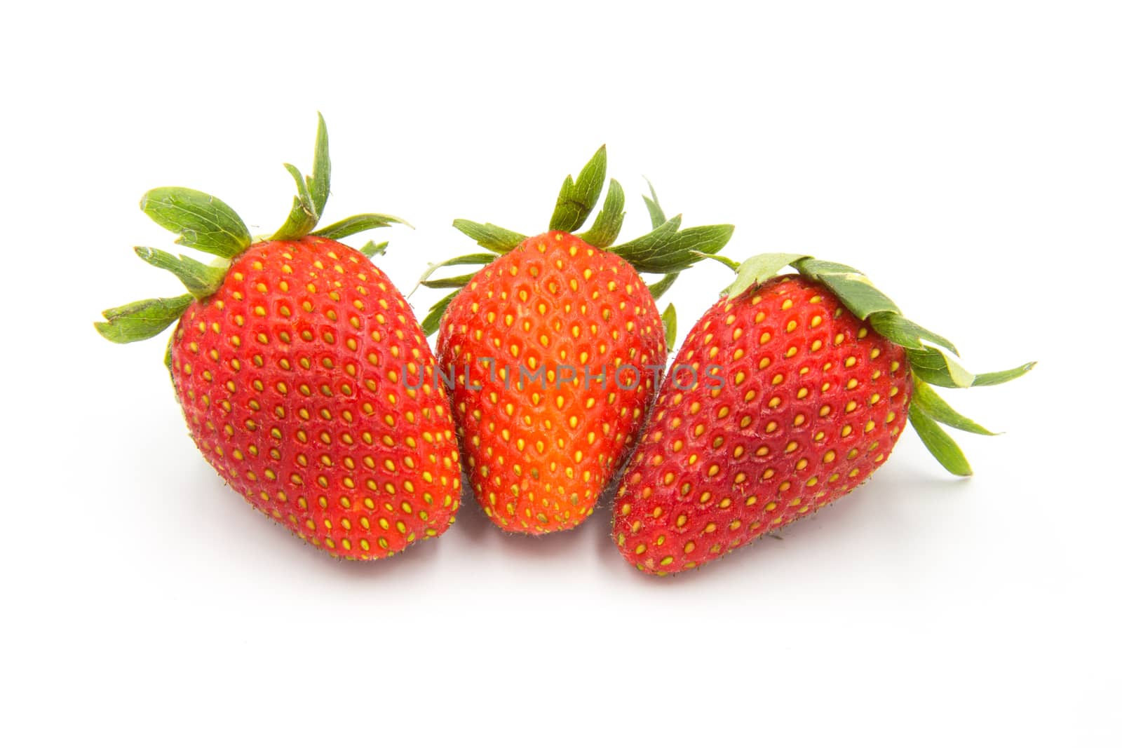 Three strawberries placed on a white background.