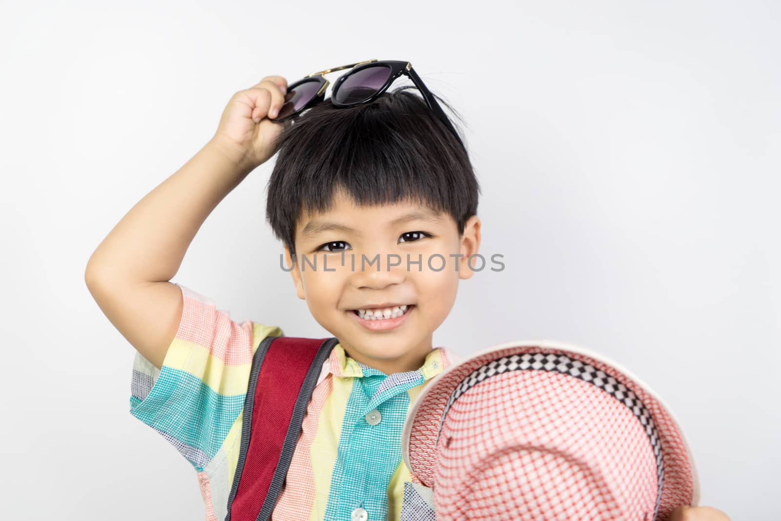 Asian kid is getting dressed up in summer clothing for summer Vacation isolated on white