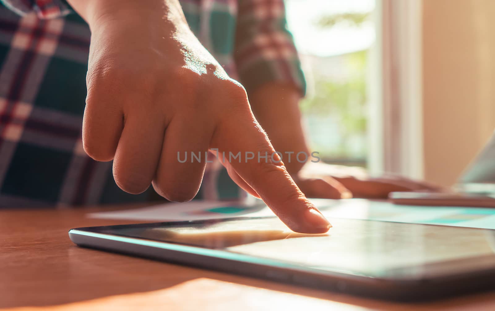 Finger touching tablet in business meeting desk