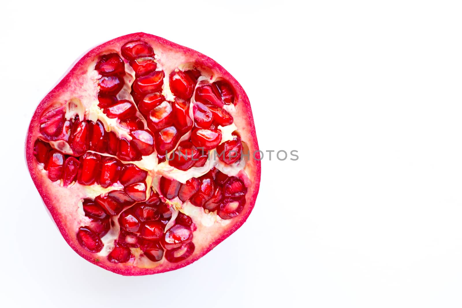 Top view of ripe pomegranate fruiton white background. Copy space