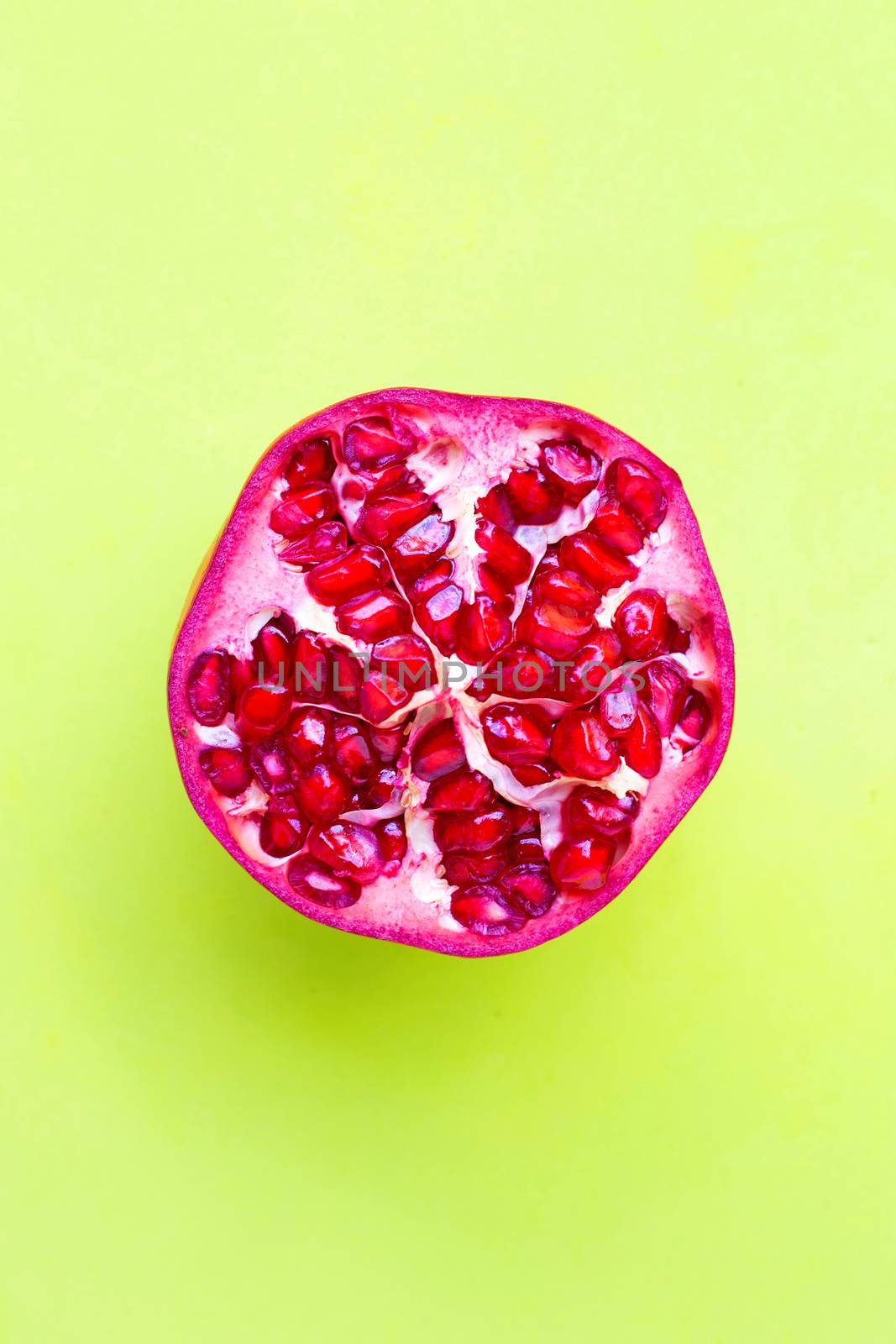 Top view of ripe pomegranate fruit on green background.