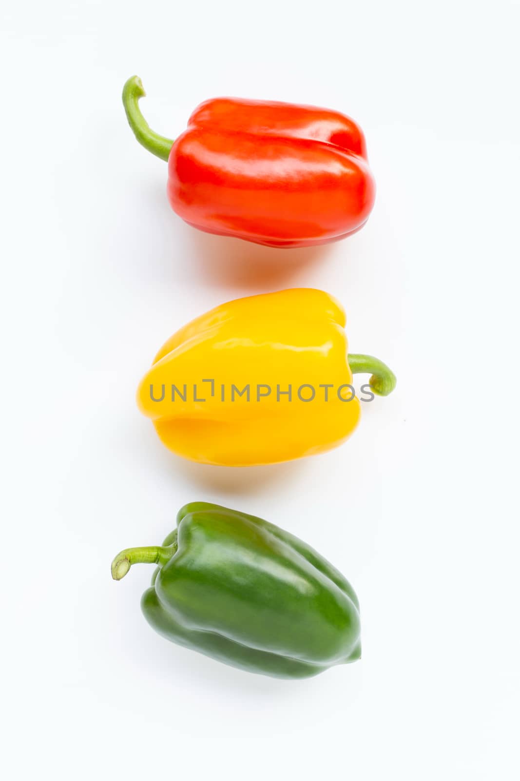 Green, yellow and red fresh bell pepper on white background.