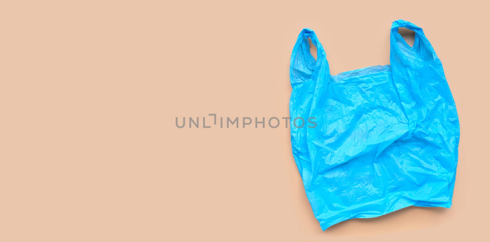 Blue plastic bag on browm background. Copy space