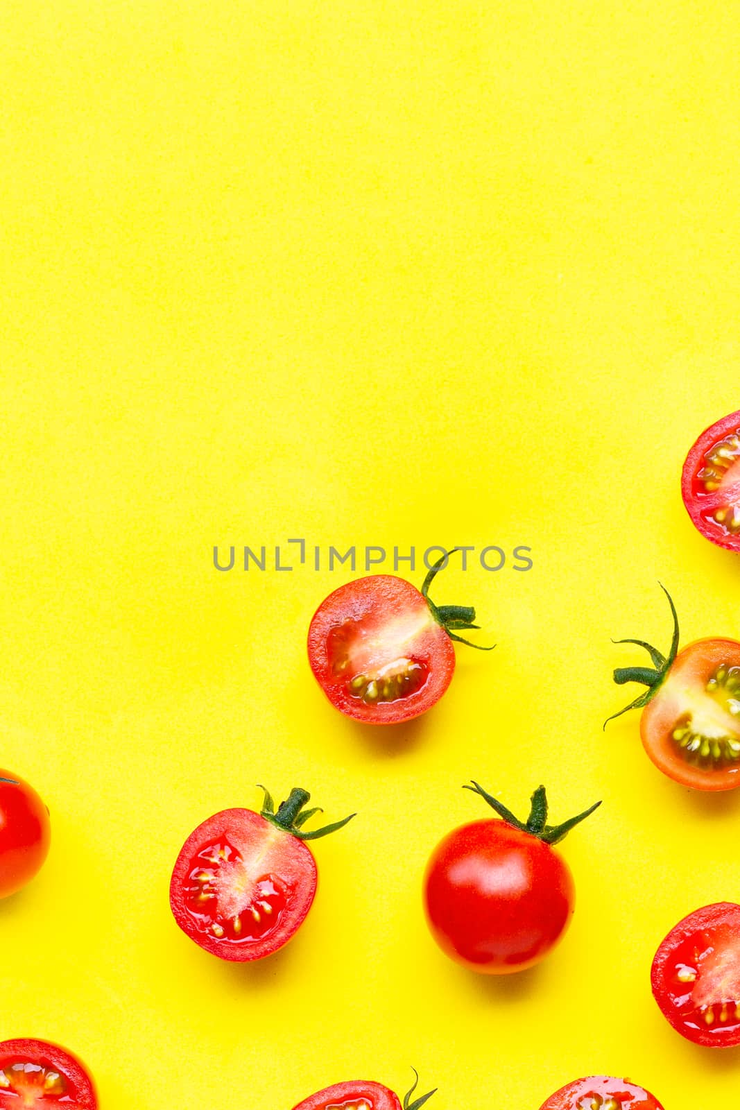 Fresh tomatoes, whole and half cut isolated on yellow background by Bowonpat