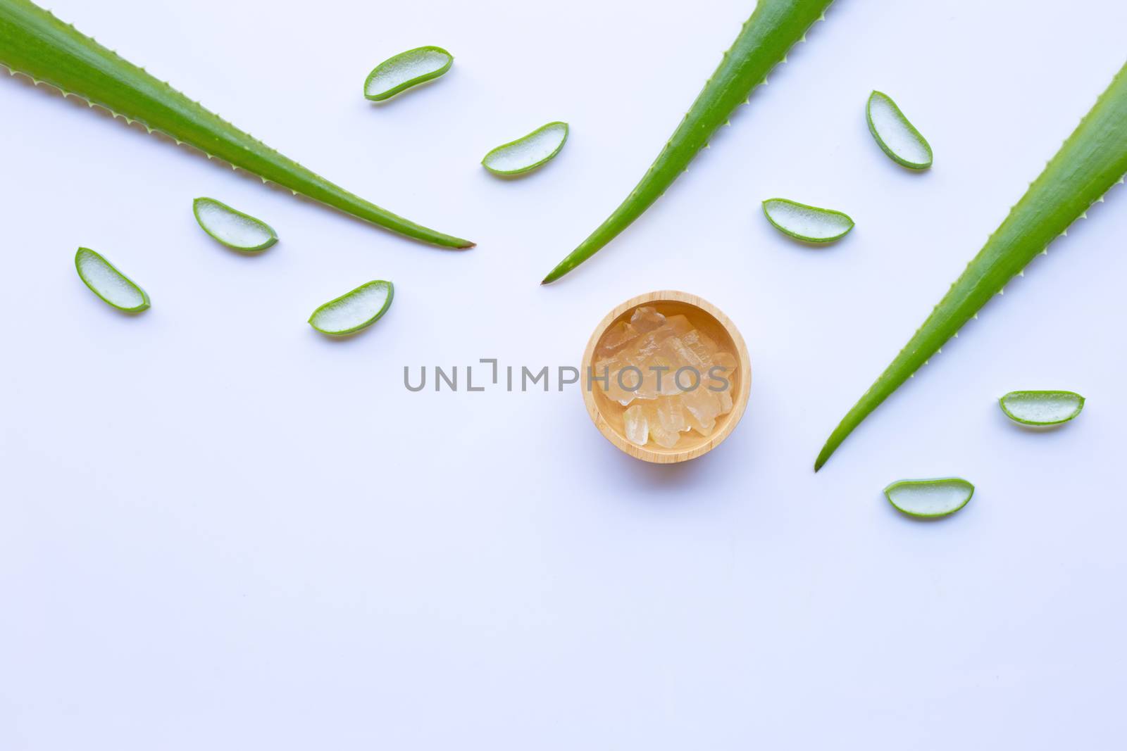 Aloe vera and slices with aloe vera gel in wooden bowl on white background. Copy space