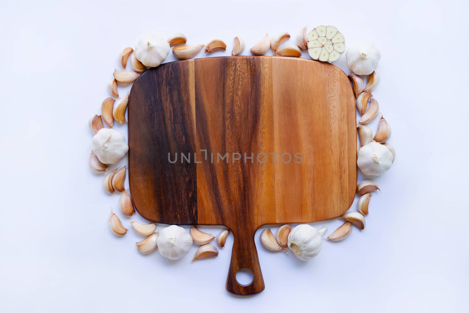 Garlic with wooden cutting board on white background.