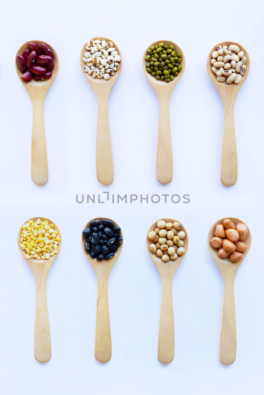 Different beans, legumes on wooden spoon on white background.