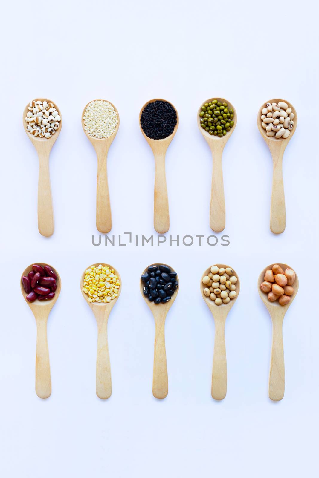Different beans, legumes on wooden spoon on white background.