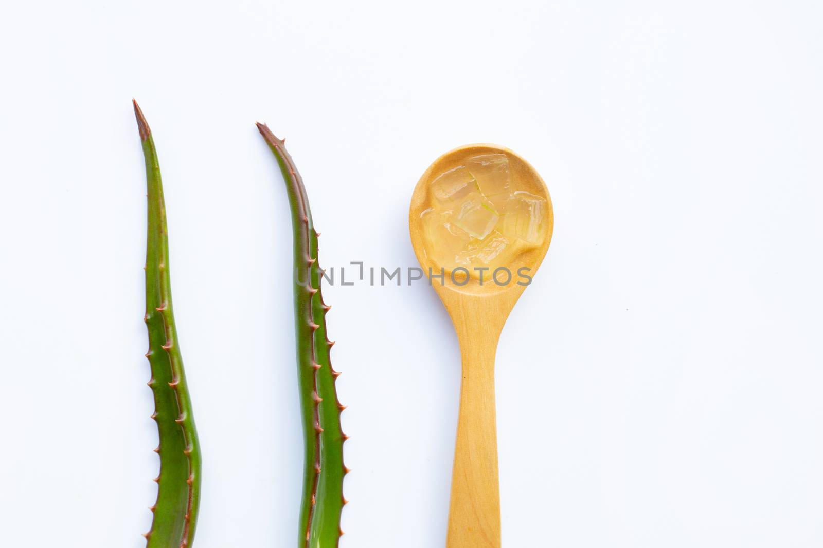 Aloe vera gel on wooden spoon with aloe vera on white background.