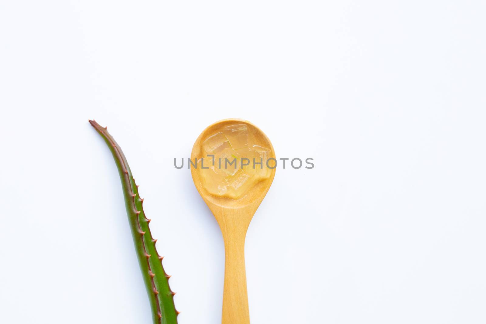 Aloe vera gel on wooden spoon with aloe vera on white background.
