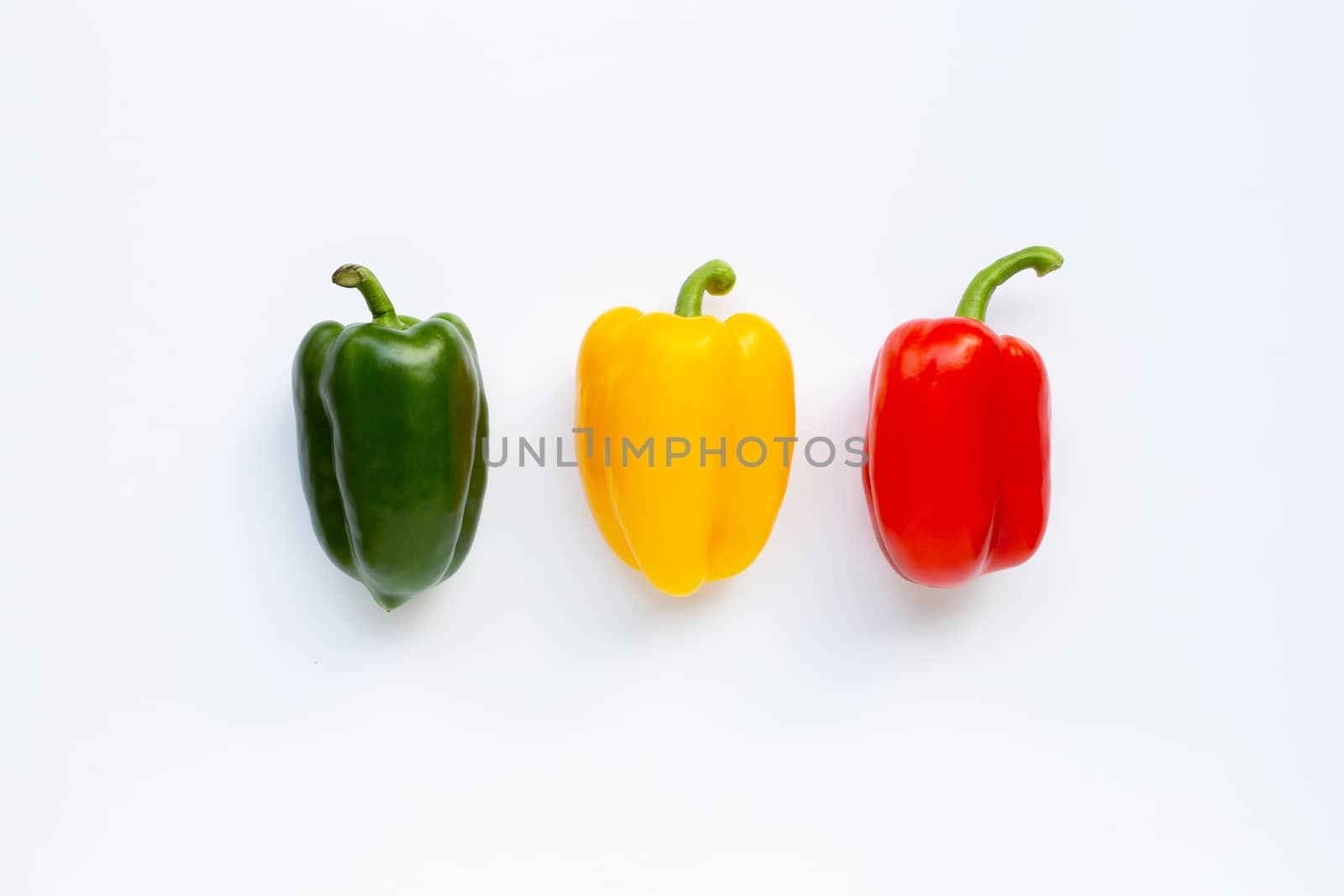 Green, yellow and red fresh bell pepper on white background.