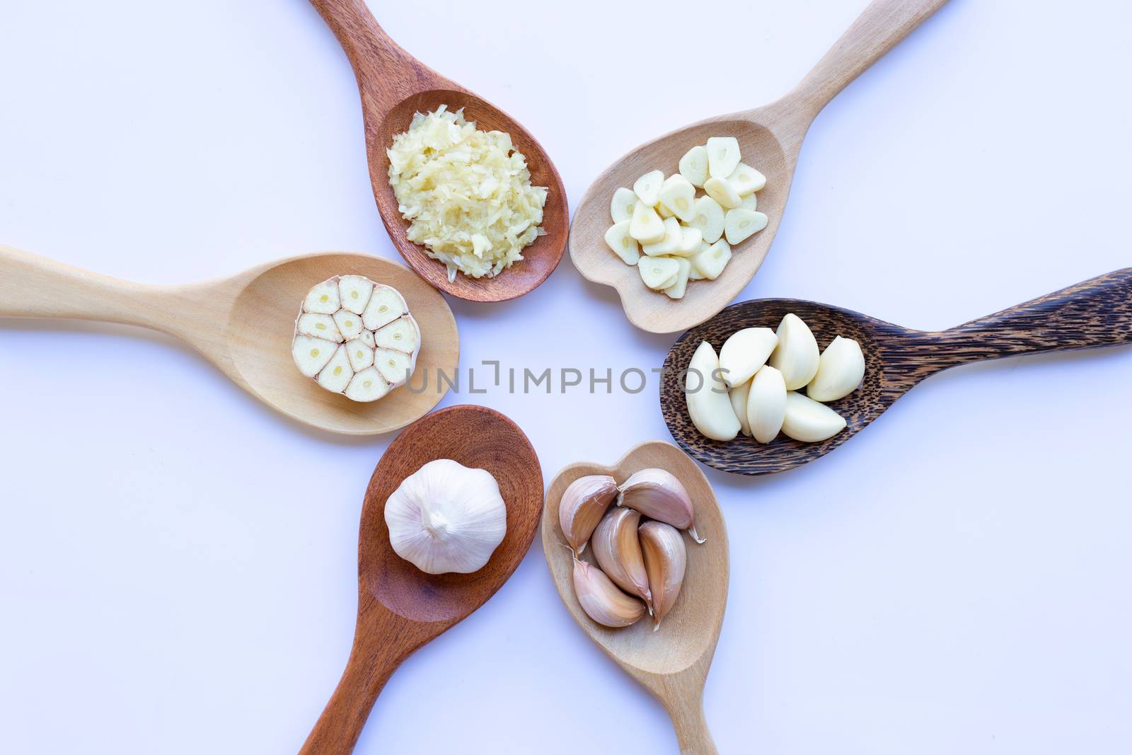 Garlic on wooden spoon on white background