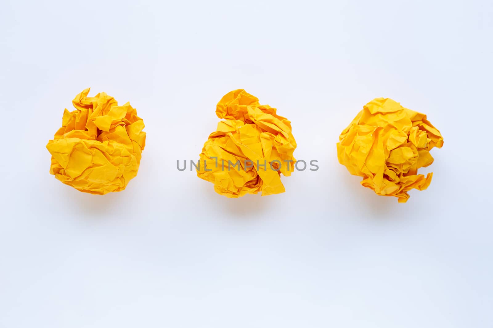 Yellow crumpled paper ball isolated on white background.