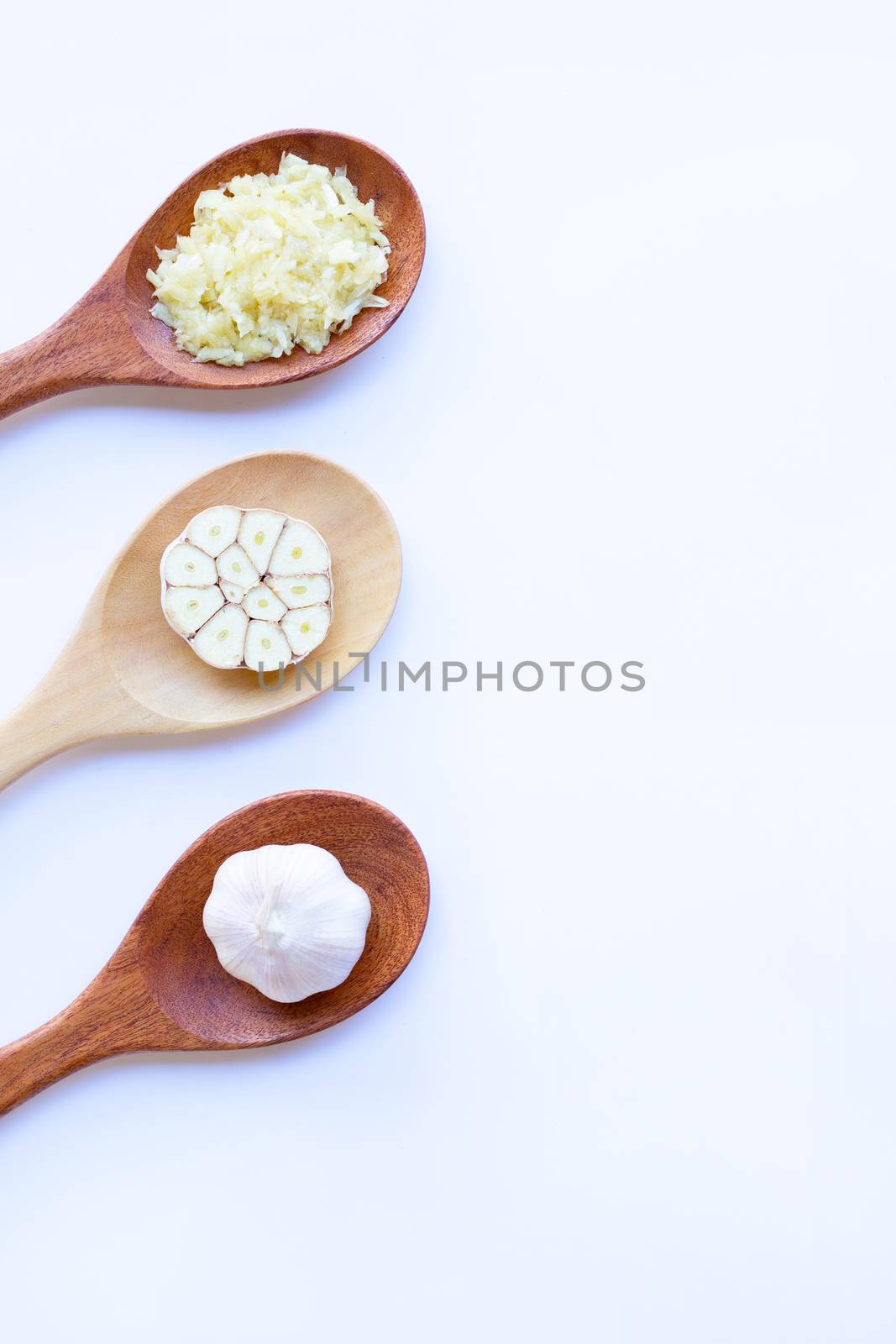Garlic on wooden spoon on white by Bowonpat