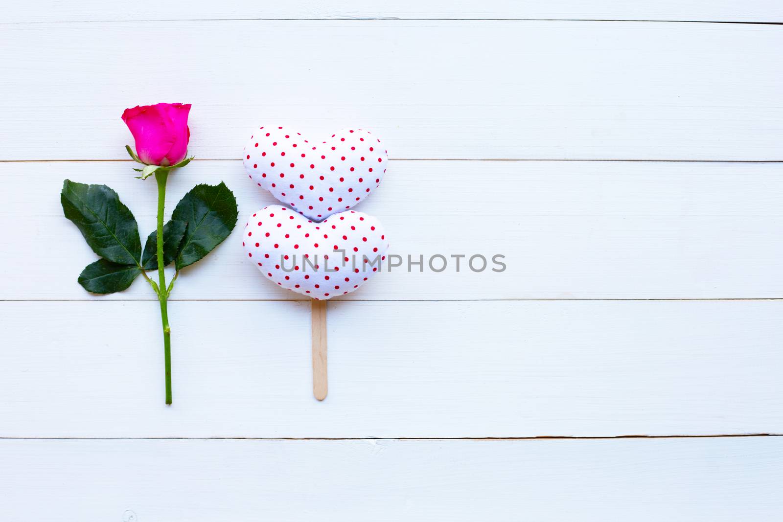Rose and valentine's hearts on white wooden background. Concept for Valentine's Day