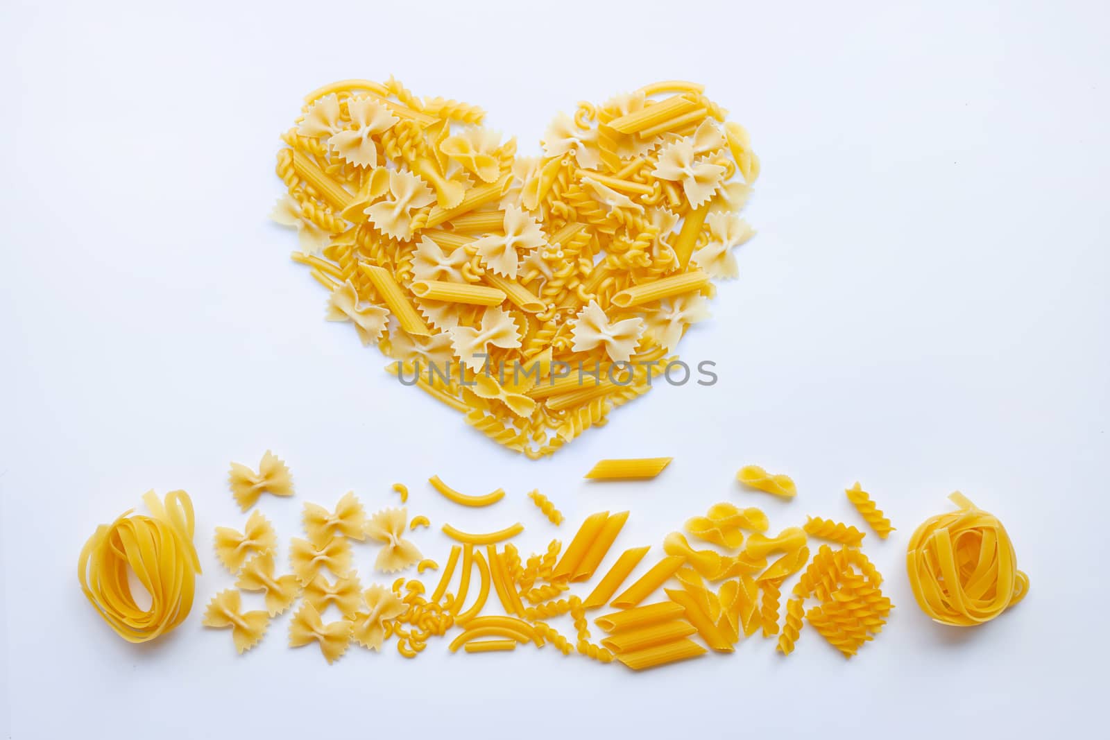 Different types of dry pasta on white background