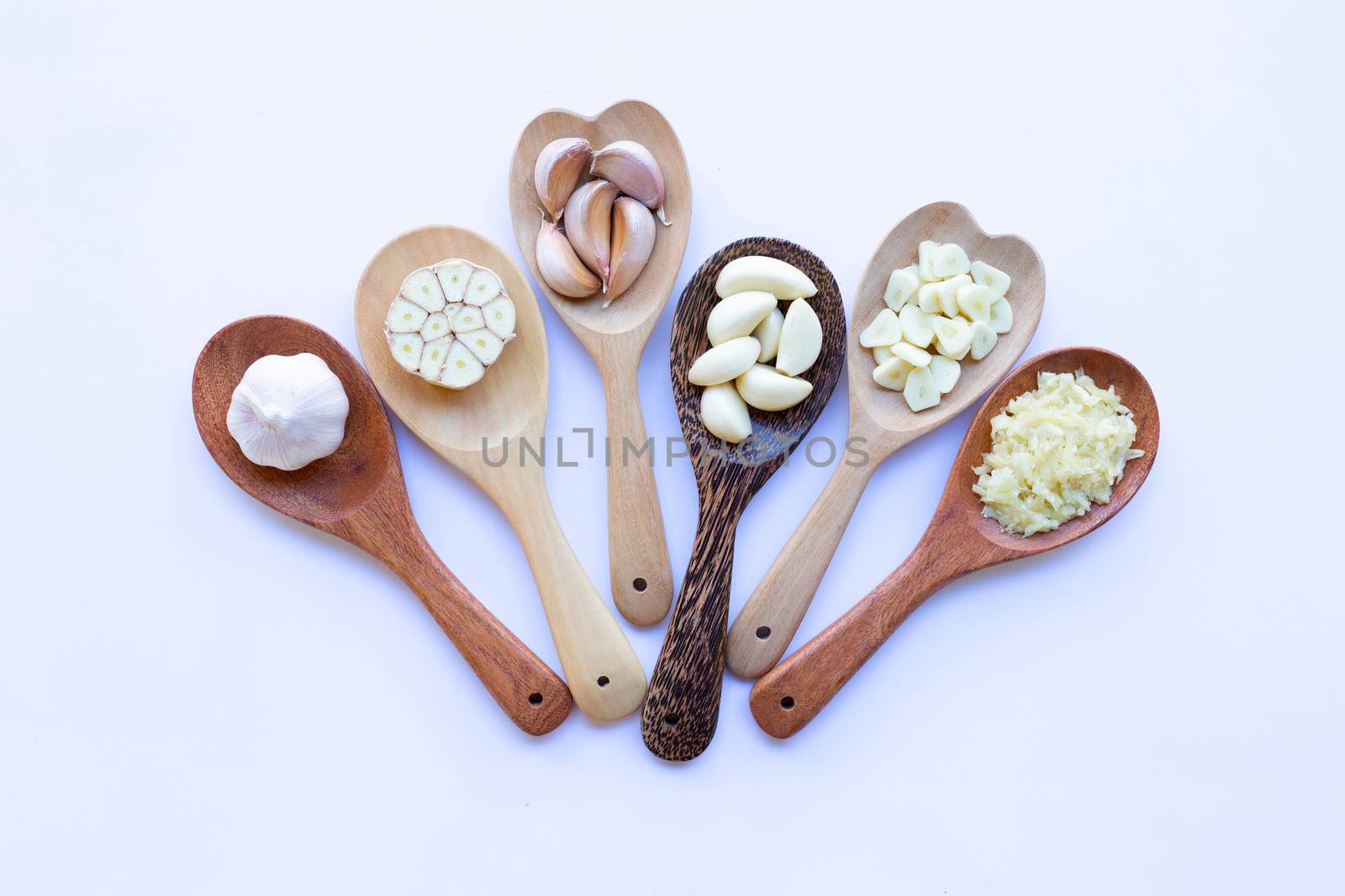 Garlic on wooden spoon on white background
