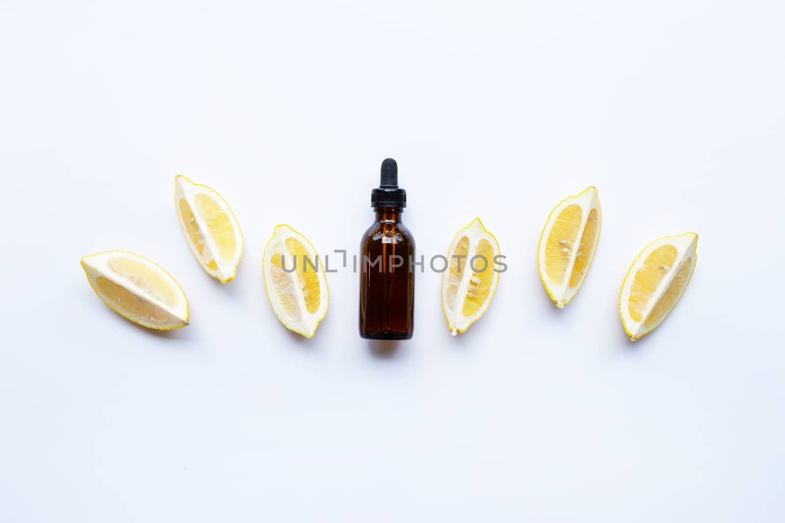 Bottle with lemon essential oil on white background