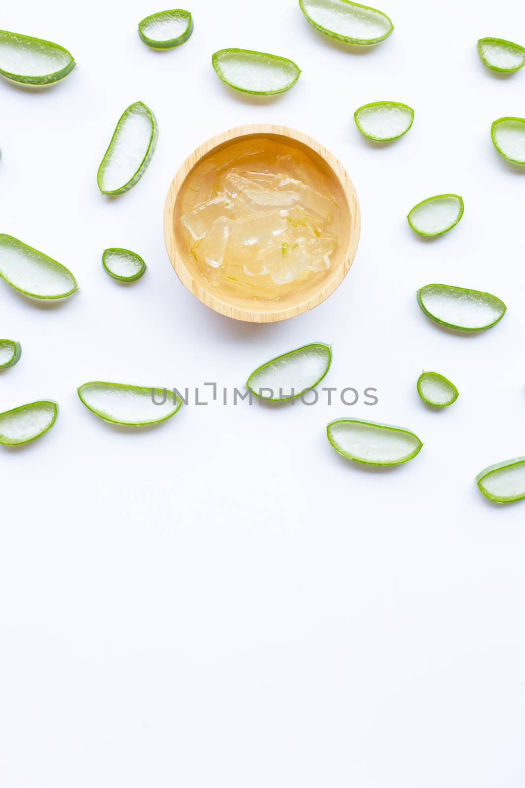 Aloe vera slices with aloe vera gel in wooden bowl on white background. Copy space