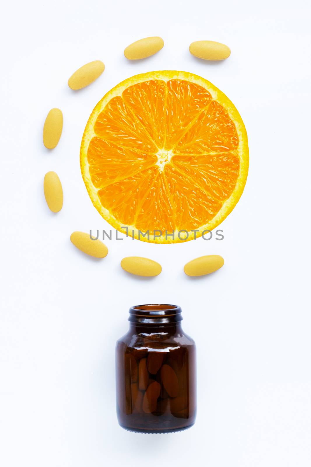 Vitamin C bottle and pills with orange fruit on white background