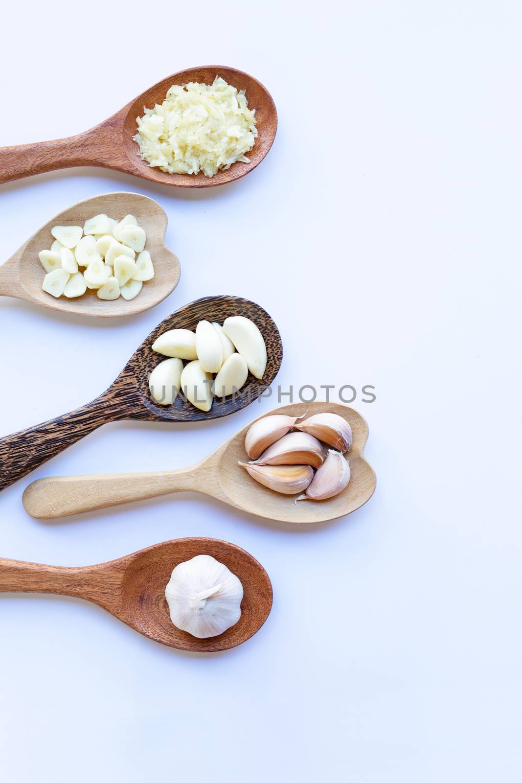Garlic on wooden spoon on white background.