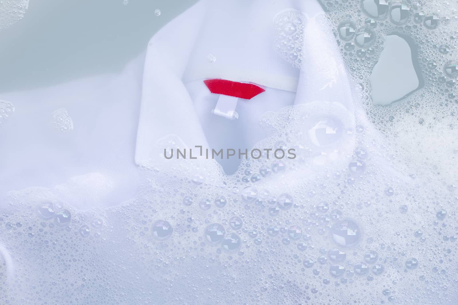 Soak a cloth before washing, white polo shirt. Top view