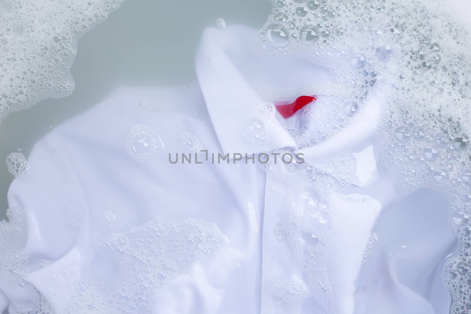Soak a cloth before washing, white polo shirt. Top view