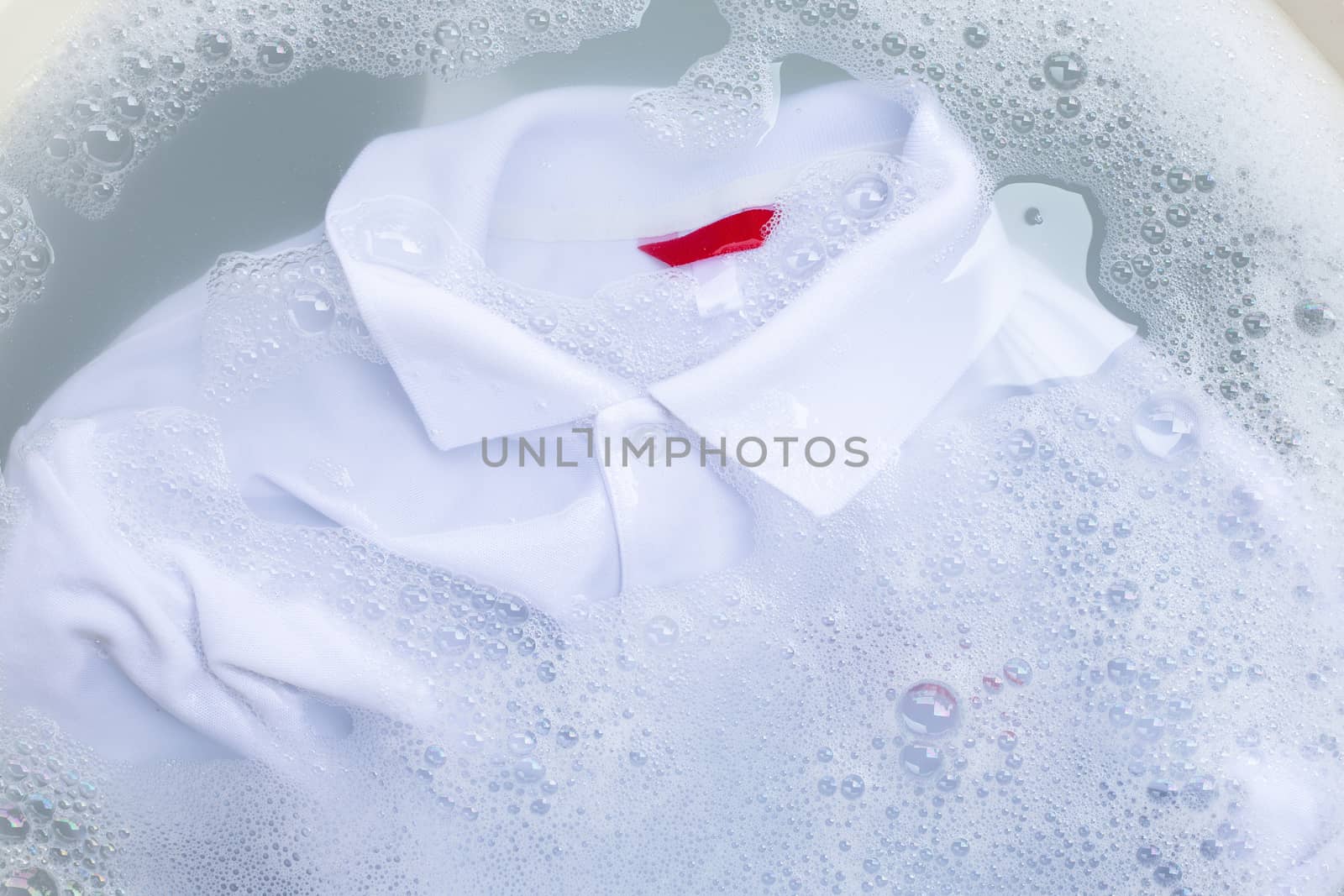 Soak a cloth before washing, white polo shirt.  by Bowonpat