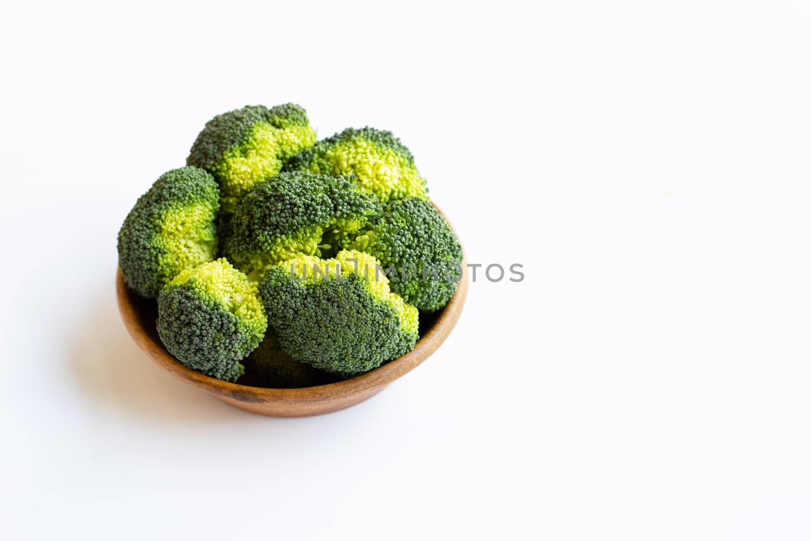 Broccoli in wooden bowl on white background