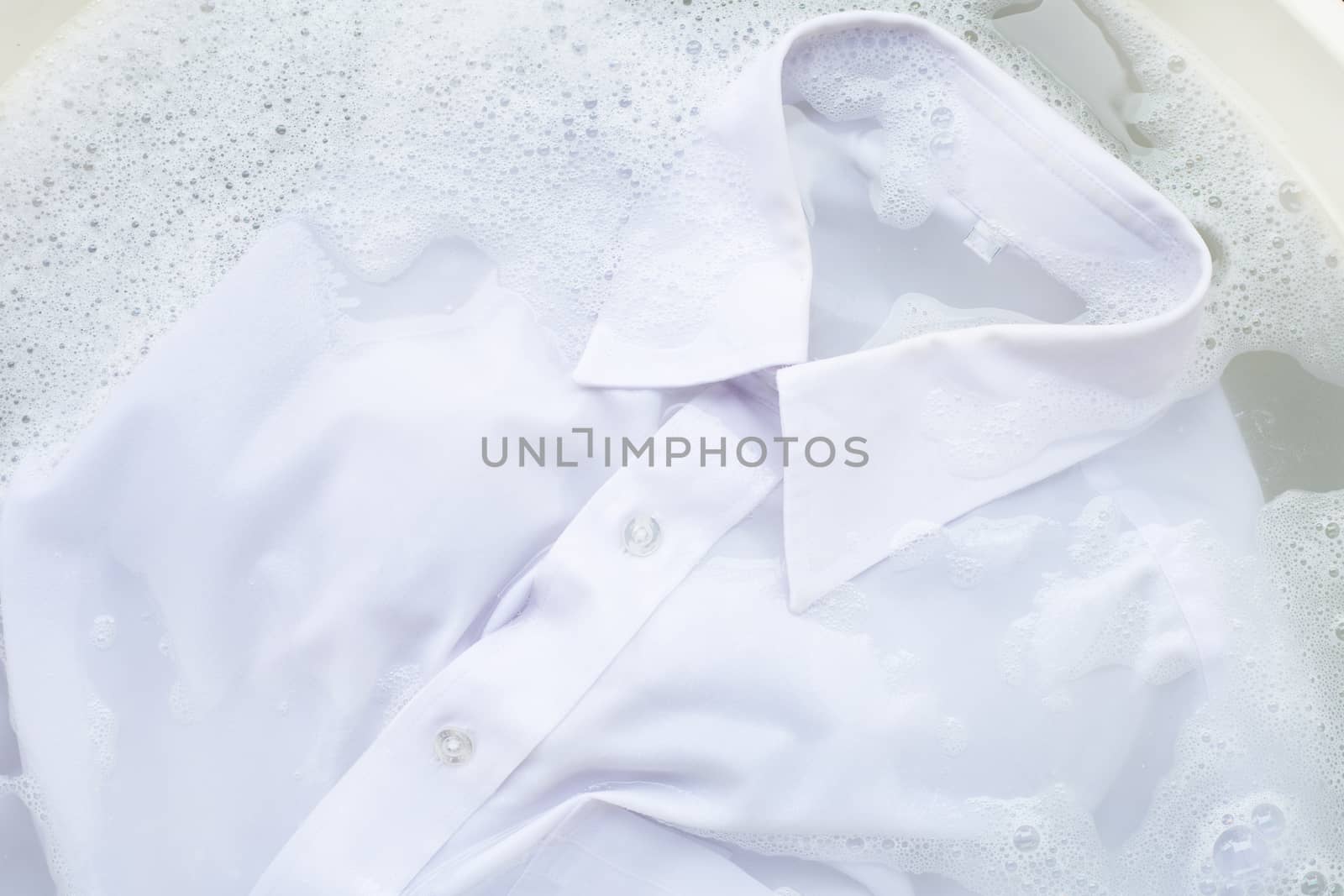 Soak  cloth before washing, white shirt by Bowonpat